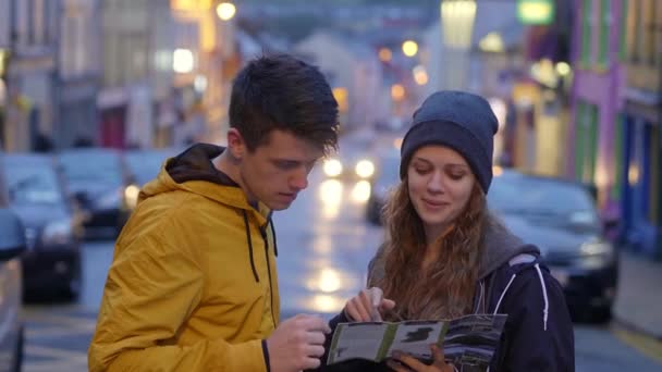 Jeune couple en voyage touristique vérifie la carte — Video