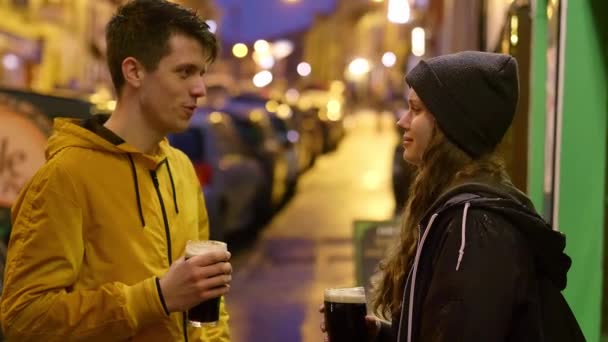 Dois amigos à frente de um pub irlandês a beber cerveja. — Vídeo de Stock