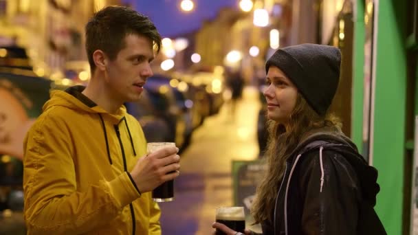 Dwóch przyjaciół ze szklanką piwa na ulicach miasteczka — Wideo stockowe