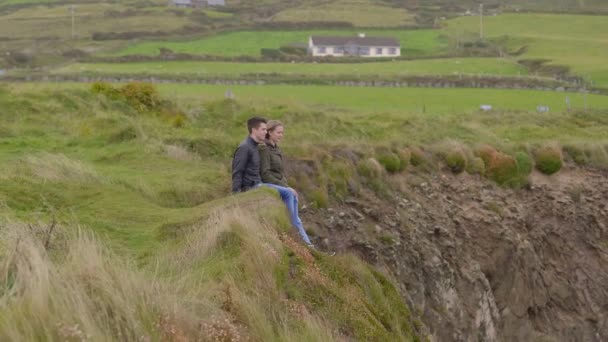 Dva přátelé sedí na vrcholu útesu v Dingle peninsula — Stock video