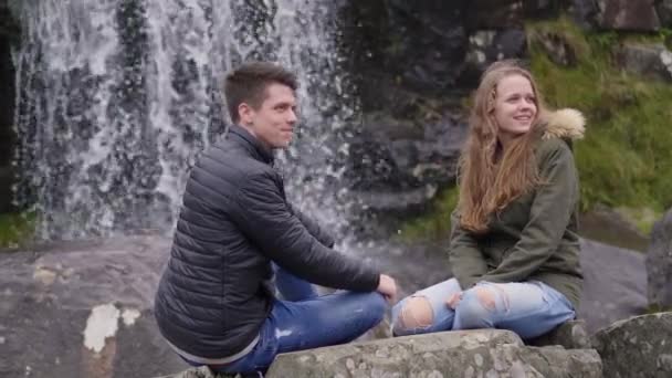 Ein wunderbarer Ort zum Entspannen - zwei Freunde vor einem Wasserfall — Stockvideo