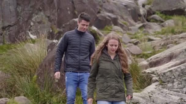 Två vänner vandra genom det steniga och grov landskapet i Irland — Stockvideo