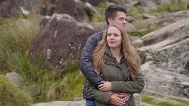 Jong koppel in liefde genieten van het fantastische landschap in de bergen van Ierland — Stockvideo