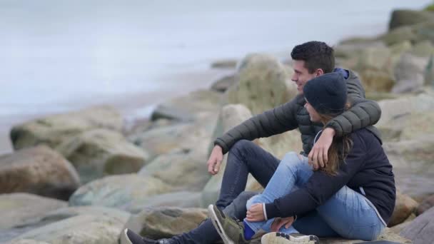 Счастливая влюбленная пара отдыхает на пляже — стоковое видео