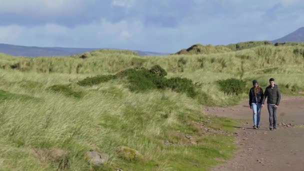 Entspannter Spaziergang durch die grasbewachsenen Dünen Irlands — Stockvideo