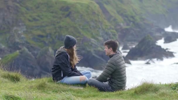 Zwei Freunde entspannen sich an den steilen Klippen Irlands — Stockvideo
