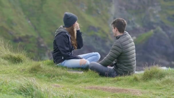 在爱的年轻夫妇放松在爱尔兰西海岸的丘陵 — 图库视频影像