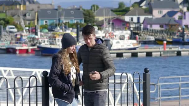 Young couple takes a selfie at the harbor of Dingle — Stock Video