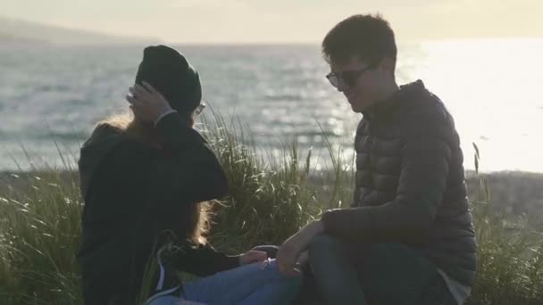 İki arkadaş sahilde otururken iyi eğlenceler — Stok video