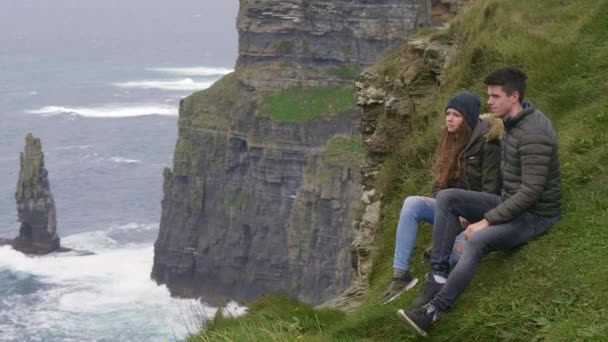 Jovem casal apaixonado viajar para as falésias de Moher na Irlanda — Vídeo de Stock