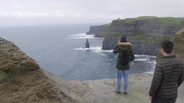 Pareja viaja a los acantilados de Moher en Irlanda — Vídeo de stock