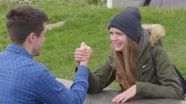 Couple has fun with arm-wrestling on a table — Stock Video