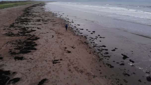 Joven camina sobre una playa en el Océano Atlántico — Vídeo de stock