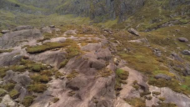 Vlucht naar een jong meisje, alleen zittend op een rots — Stockvideo