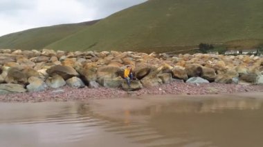 Genç çift Rossbeigh İrlanda'nın kayalık plaj rahatlatır