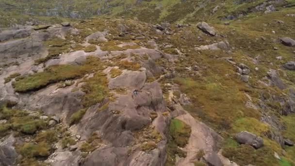 Mädchen klettert über Felsen in den Bergen — Stockvideo