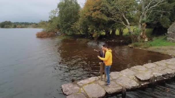 Young couple in love take a selfie at a romantic lake — Stock Video