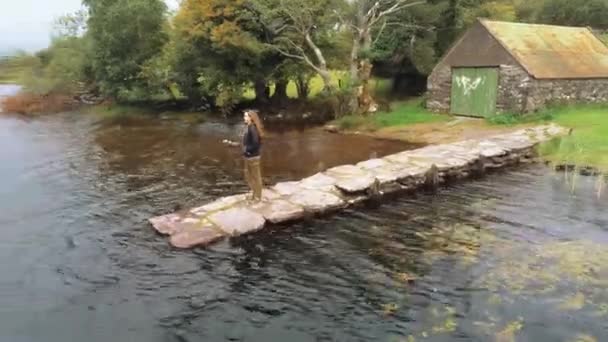 Vuelo alrededor de una joven mujer de pie en un muelle — Vídeos de Stock