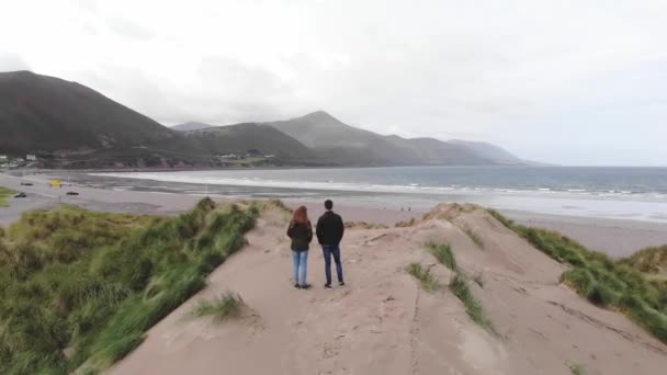 Flygning över ett ungt par på stranden — Stockvideo