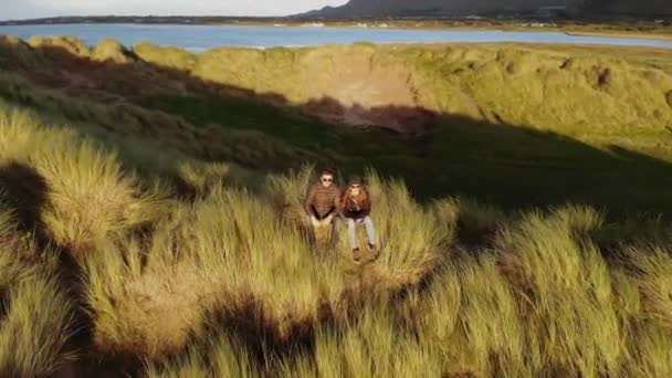 Vol autour d'un couple assis à la plage — Video