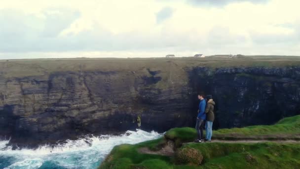 Volo intorno a una coppia in piedi sul bordo di una scogliera — Video Stock