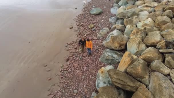 Dos amigos caminan por una playa de guijarros en la costa oeste irlandesa — Vídeo de stock