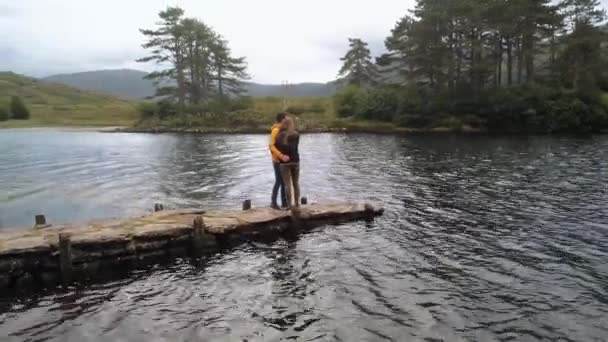 Jong koppel in liefde staat op een romantisch meertje in Ierland — Stockvideo