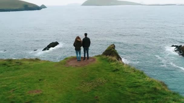 Vlucht rond een paar staande op Dunquin Pier op de westkust van Ierland — Stockvideo