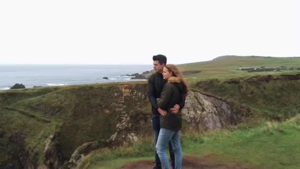 Vuelo alrededor de una pareja enamorada de pie al borde de un acantilado — Vídeos de Stock