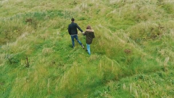 Casal caminha sobre os campos de grama da Península de Dingle, na Irlanda — Vídeo de Stock