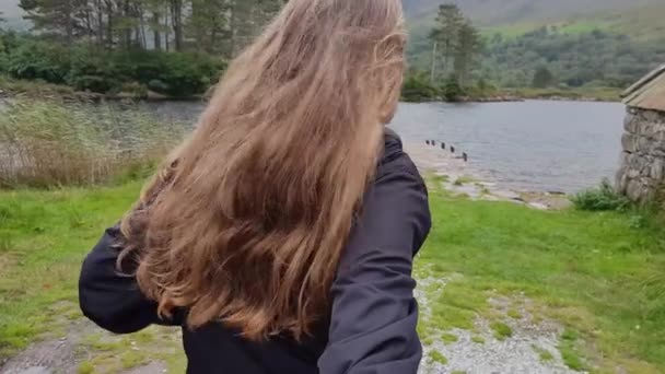 Девушка тащит своего парня на романтическое озеро — стоковое видео