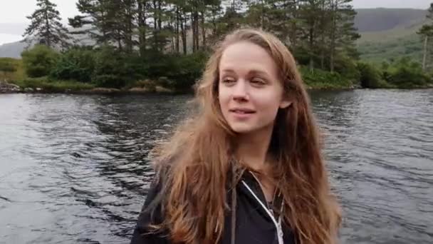 Mujer joven está abrumada por el paisaje increíble en un hermoso lago — Vídeo de stock