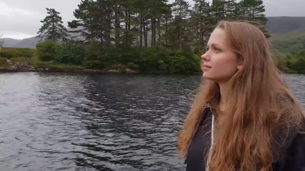 Pretty girl stands at a beautiful lake in the nature — Stock Video