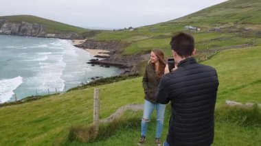 Kız İrlandalı Batı sahilinde fotoğrafını çekmek genç adam seviyor
