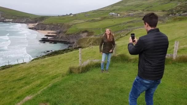 Ładna dziewczyna pozuje dla swojego chłopaka na zachodnim wybrzeżu Irlandii — Wideo stockowe