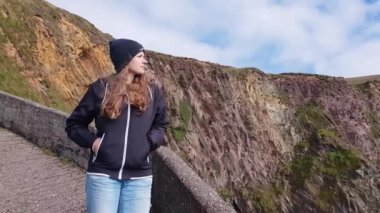 Genç kadın İrlandalı Batı sahilinde dik kayalıklarla tarafından etkilendim