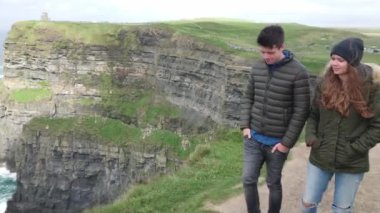 Genç çift İrlanda seyahat Moher dik kayalıklarla yürümek