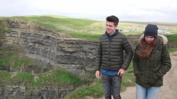 Dois amigos caminham na beira dos penhascos íngremes de Moher — Vídeo de Stock