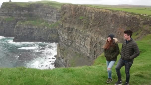 Jong stel geniet van het adembenemende landschap op de Cliffs of Moher op de Ierse westkust — Stockvideo