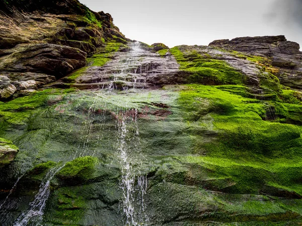 Prachtige waterval over mossy stenen in de inham van Tintagel in Cornwall — Stockfoto