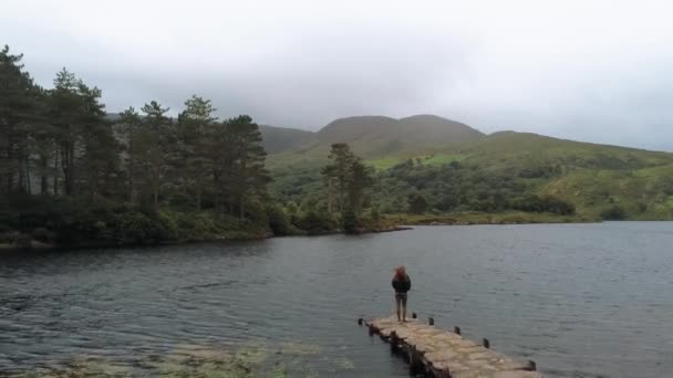 Jovem mulher em um belo lago na Irlanda — Vídeo de Stock