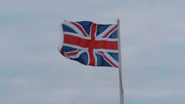 Bandeira britânica acenando ao vento na costa da Cornualha — Vídeo de Stock