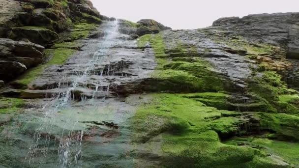 Hermosa cascada sobre piedras musgosas en la cala de Tintagel en Cornwall — Vídeo de stock