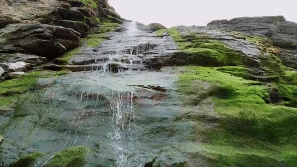 Bela cachoeira sobre pedras musgosas na enseada de Tintagel na Cornualha — Vídeo de Stock