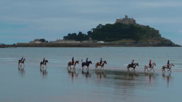 Orang-orang menunggang kuda di pantai Marazion di Cornwall — Stok Video
