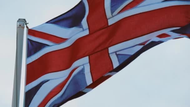 Bandera de Gran Bretaña ondeando en el viento en la costa inglesa — Vídeo de stock