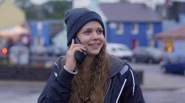 Genç güzel kadın bir telefon cep telefonunu üzerinde alır.