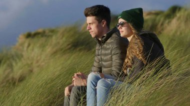 Mutlu çift reed çimlere limanda oturuyor