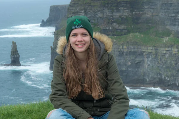 Junge Frau liebt irland - sitzt an den berühmten klippen von moher — Stockfoto