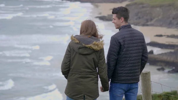 Mladý pár v lásce stojí na strmé útesy irské západního pobřeží — Stock fotografie
